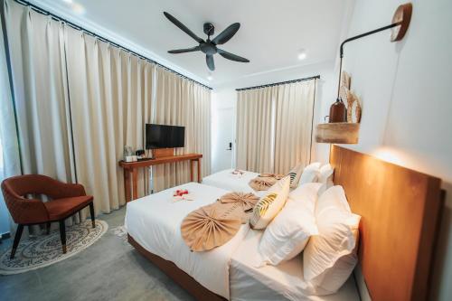 a hotel room with a bed and a ceiling fan at Belena Maldives in Thoddoo
