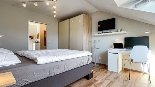 a bedroom with a bed and a desk with a computer at FeWo Siebenstern in Winterberg