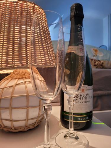 a bottle of wine and two wine glasses on a table at Ferienwohnung Hausnummer 1, Kontaktloser Self check-in in Zweibrücken