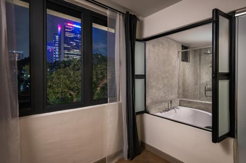 a bathroom with a bath tub and a window at BRYQS Hotel KL Sentral in Kuala Lumpur