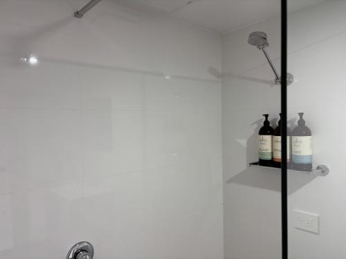a shower with bottles of wine on a shelf at Near the CBD Perfect for Large Groups & Parking in Kings Meadows