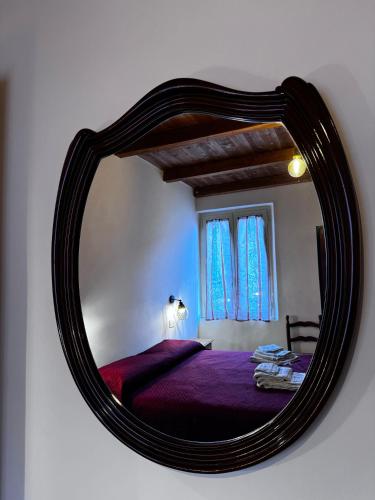 a mirror on a wall with a bed in a room at Vicolo della Quiete Anagni in Anagni