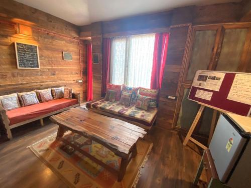 a room with a couch and a table in a room at MeenaBagh Villa Rooms & Cafe in Shimla