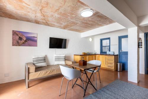 a living room with a couch and a table and chairs at Speelhuis Collection in Langebaan