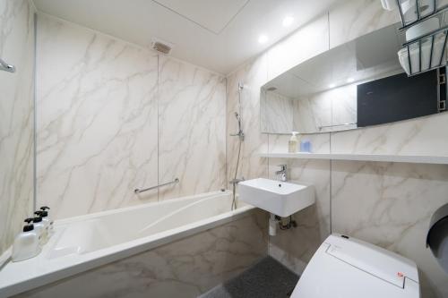 a bathroom with a sink and a tub and a toilet at Hotel Kabo Pyeongtaek in Pyeongtaek