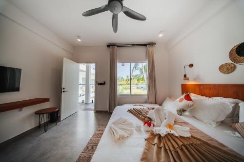 a bedroom with a large bed with a ceiling fan at Belena Maldives in Thoddoo