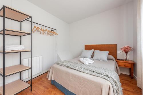 a bedroom with a bed and a book shelf at Pensión Casa Castelao 31 O Grove in O Grove