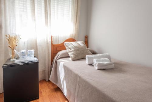 a bedroom with a bed with two towels on it at Pensión Casa Castelao 31 O Grove in O Grove