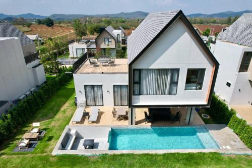 an aerial view of a house with a swimming pool at แคนเทอเบอรี่ เขาใหญ่ พูลวิลล่า สระน้ำอุ่น CANTERBURY Khaoyai in Ban Rai Khlong Sai
