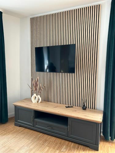 a entertainment center with a television on a wall at Lindenallee Apartments in Berlin