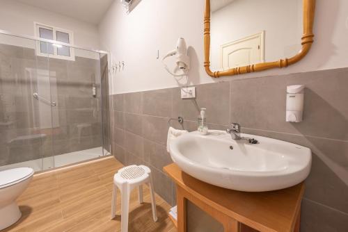 Un baño con lavabo, inodoro y ducha. en Pensión Casa Castelao 31 O Grove, en O Grove