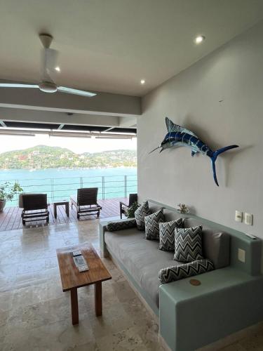a living room with a couch and a shark sculpture on the wall at El Nido Casa 4 in Zihuatanejo