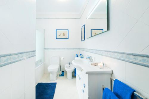 a white bathroom with a sink and a toilet at Ericeira Apartment - Blue Sea in Ericeira