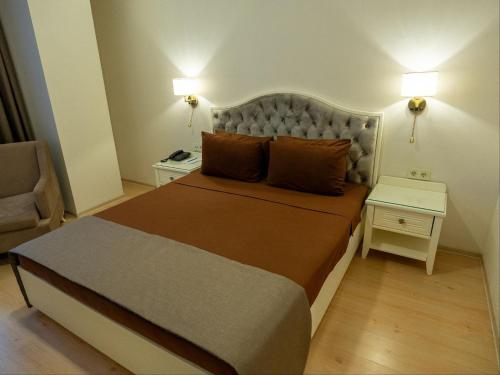 a bedroom with a large bed and a chair at Nafta Sanatorium in Naftalan