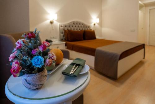 a living room with a bed and a table with flowers at Nafta Sanatorium in Naftalan