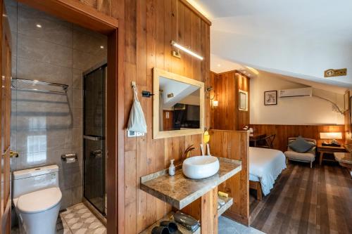 ein Badezimmer mit Waschbecken und Dusche in einem Zimmer in der Unterkunft Pillow Window & Listen to Rain Hotel Museum Branch Pingjiang Road, Suzhou in Suzhou