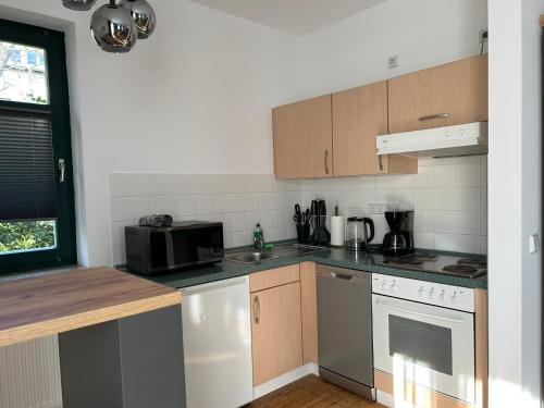 a kitchen with a microwave oven and a stove at Lindenallee Apartments in Berlin