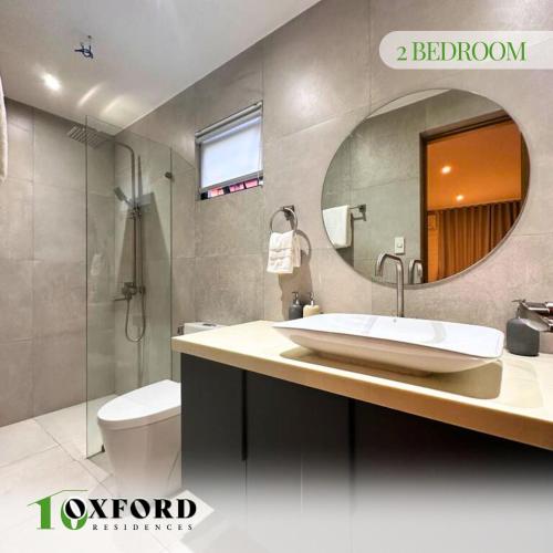 a bathroom with a sink and a toilet and a mirror at 10 Oxford Residences in Quezon City