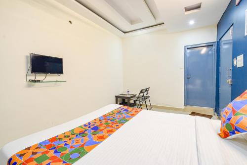a bedroom with a bed and a flat screen tv at FabHotel Broholic Prime Suites - Nr Nexus Mall, Kukatpally in Kondapur