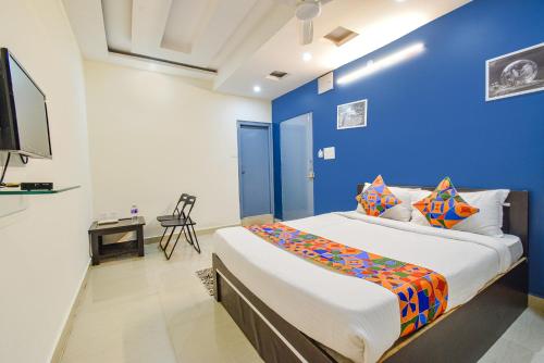 a blue room with a bed and a tv at FabHotel Broholic Prime Suites - Nr Nexus Mall, Kukatpally in Kondapur