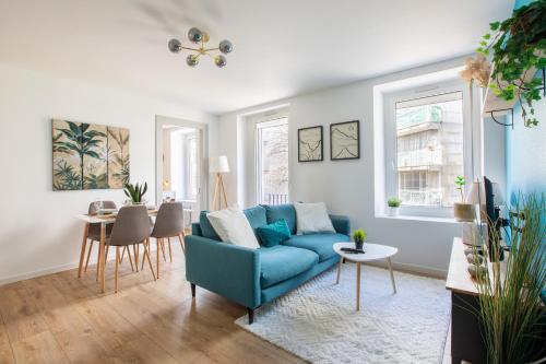 un salon avec un canapé bleu et une table dans l'établissement Proche centre ville, moderne & cosy, ultra calme, à Mulhouse