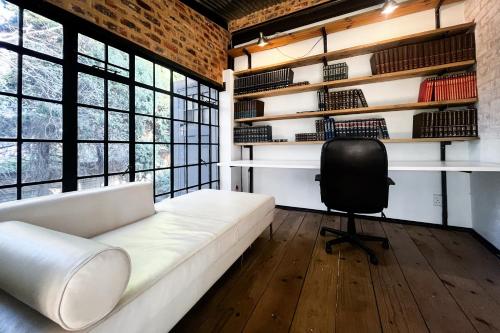 a living room with a white couch and a chair at Hagios House in Pretoria