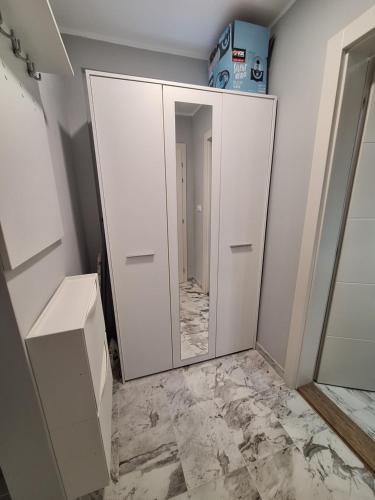 a mirror in a bathroom with a marble floor at Apartman MILOVANOVIĆ in Vrnjačka Banja