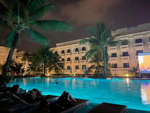 people laying on chaise lounges in front of a hotel at Palmera Villa Phu Quoc - Infinity Pools Long Beach Phu Quoc in Phu Quoc