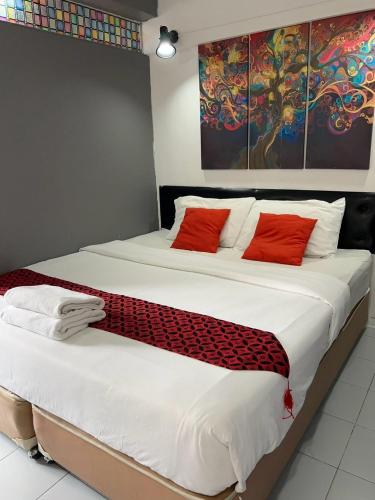 a bedroom with a large bed with red pillows at Khaosan Art Hotel in Bangkok