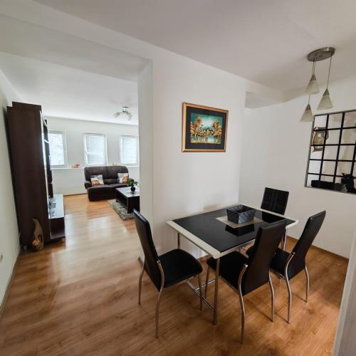 a dining room and living room with a table and chairs at Apartman - stan na dan LENJINKA in Vranje