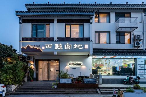 ein Gebäude mit einem Geschäft davor in der Unterkunft Pillow Window & Listen to Rain Hotel Museum Branch Pingjiang Road, Suzhou in Suzhou