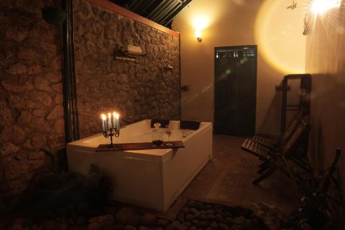 a bathroom with a bath tub with candles on it at Fifth Estate in Vagamon