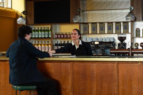 a man and a woman shaking hands at a bar at Roberta's Society Aarhus in Aarhus