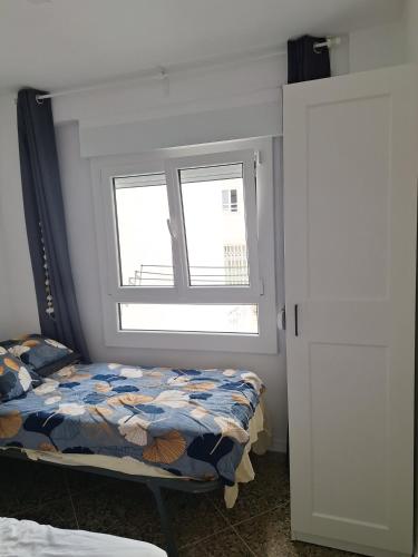 a bedroom with a bed and a window at Mar y castillo in Cullera