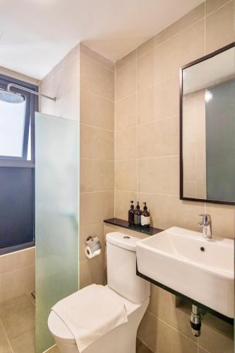 a bathroom with a toilet and a sink and a mirror at ❈ Tropicana 218 by ALV Suites ❈ in George Town