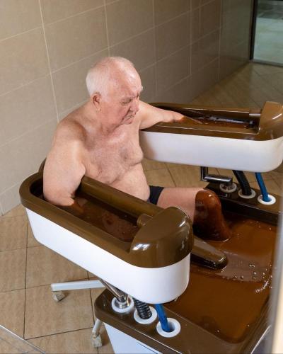 an older man sitting in a bath tub at Nafta Sanatorium in Naftalan