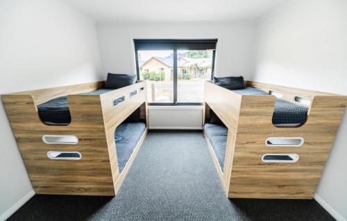 two bunk beds in a room with a window at Jimmara House Modern central holiday home in Halls Gap
