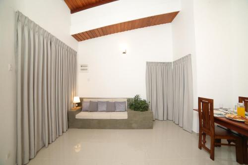a living room with a bed and a table at Kandy Mount Breeze in Sirimalwatta