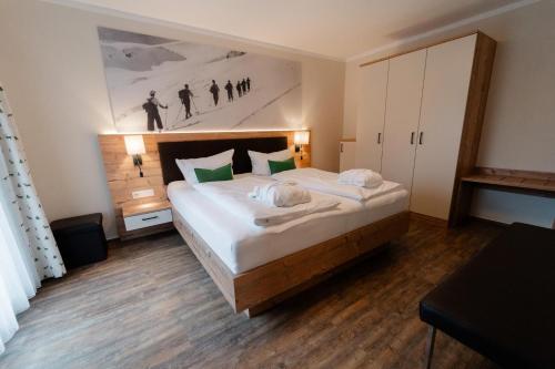 a bedroom with a large bed and a painting on the wall at Pension Gletscherblick in Fulpmes