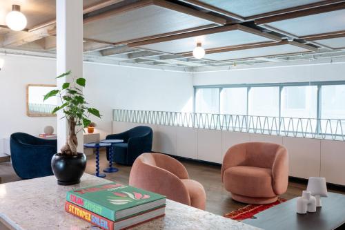 a room with chairs and a table with books at master Mazeh in Tel Aviv