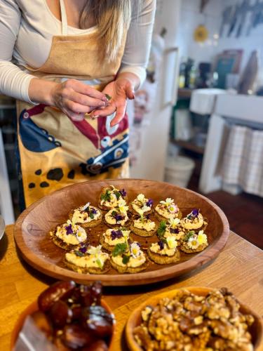 a woman standing in a kitchen with a plate of food at Mala Kmetija in Slovenske Konjice