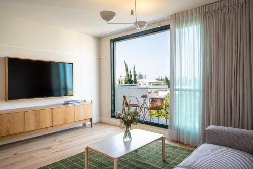 a living room with a large window and a television at master Mazeh in Tel Aviv