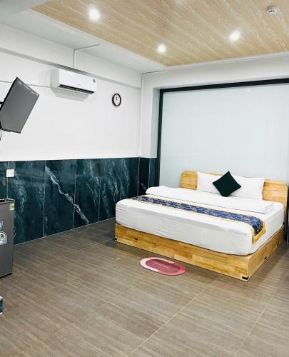 a bedroom with a bed in a room with a tv at Khách Sạn The Second in Thốt Nốt