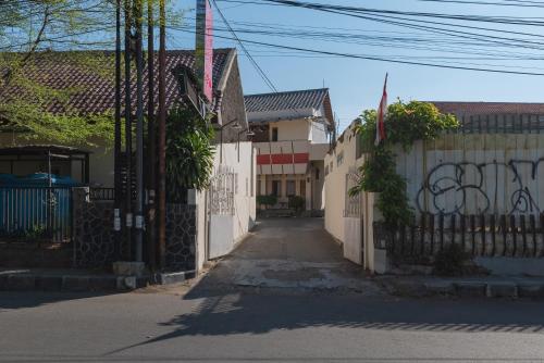 an alley with a white fence and a street at RedDoorz near Pasar Pagi 2 by Cassana in Cirebon