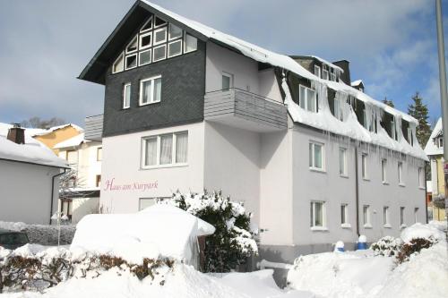 a white building with snow on the ground at Haus am Kurpark Hotel Garni in Bad Steben