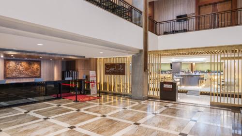 a lobby of a hotel with wooden walls and a staircase at Swiss-Belhotel Manokwari in Manokwari