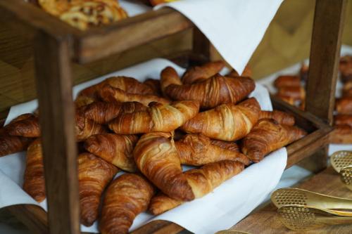 un montón de cruasanes y otros pasteles en un estante en Fletcher Hotel-Restaurant Noordsee-Ameland, en Nes