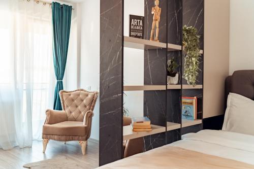 een slaapkamer met een stoel en een bed bij COZY Premium Collection - Q Studios Palas Mall Iasi in Iaşi