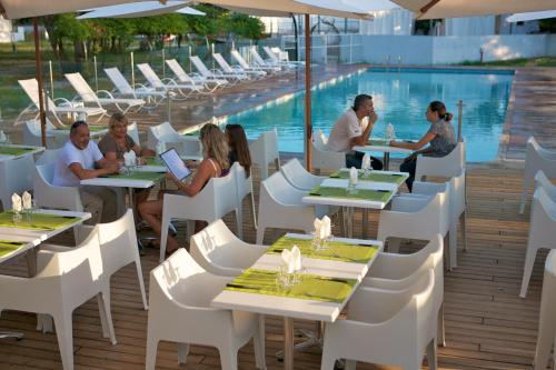 un groupe de personnes assises à des tables dans un restaurant dans l'établissement Mini Villa, à Ghisonaccia