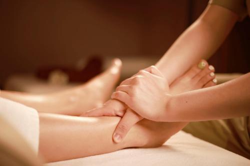 a woman sitting on a bed with her feet on at Da Nang - Mikazuki Japanese Resorts & Spa in Da Nang